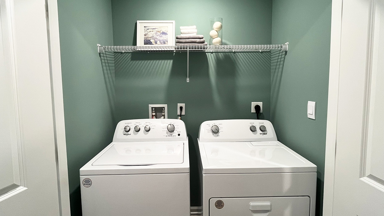 Laundry room with shelf above washer and dryer.