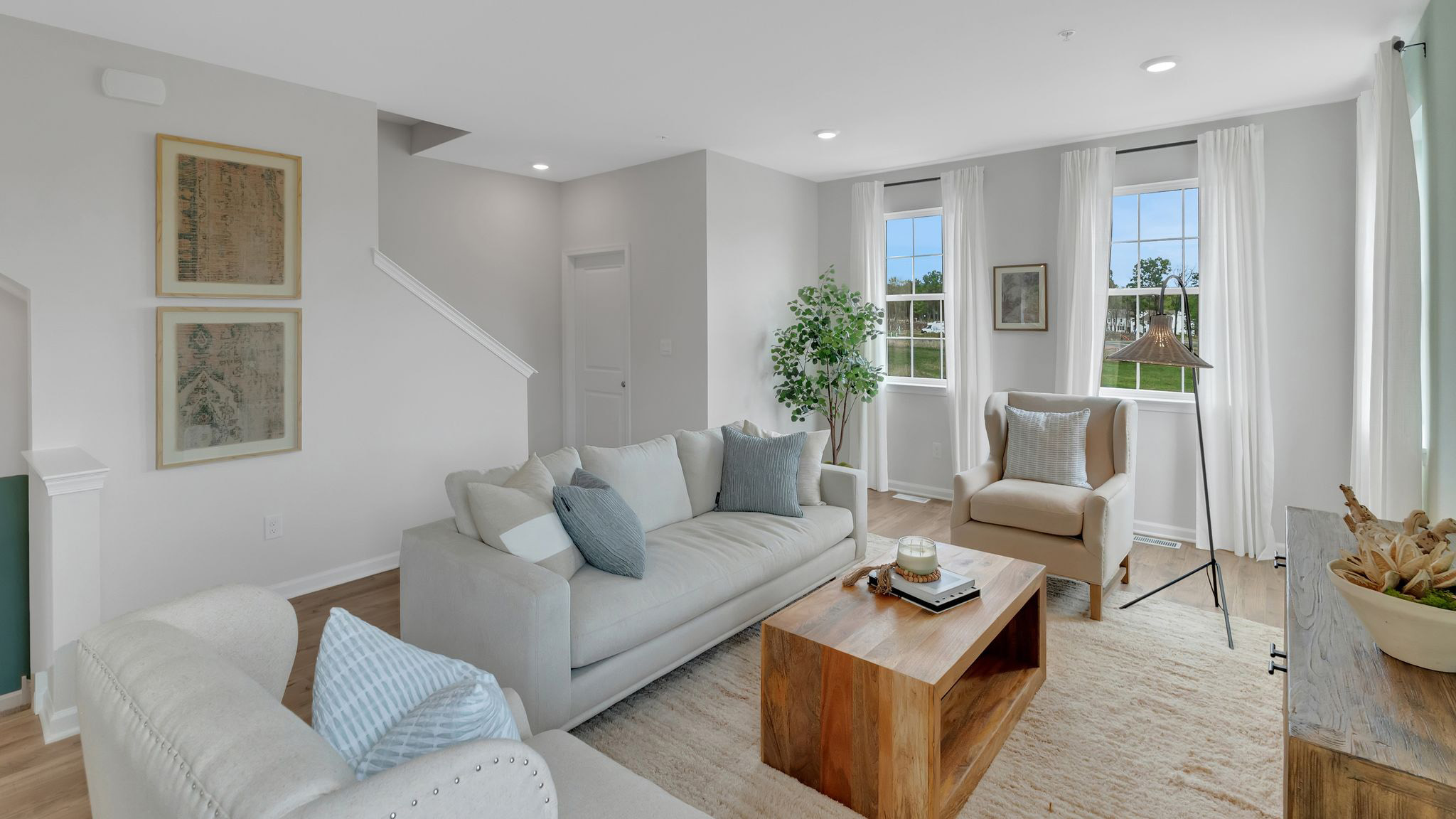 The living area on the second floor with both set of staircases in the back and a set of single windows to the right.