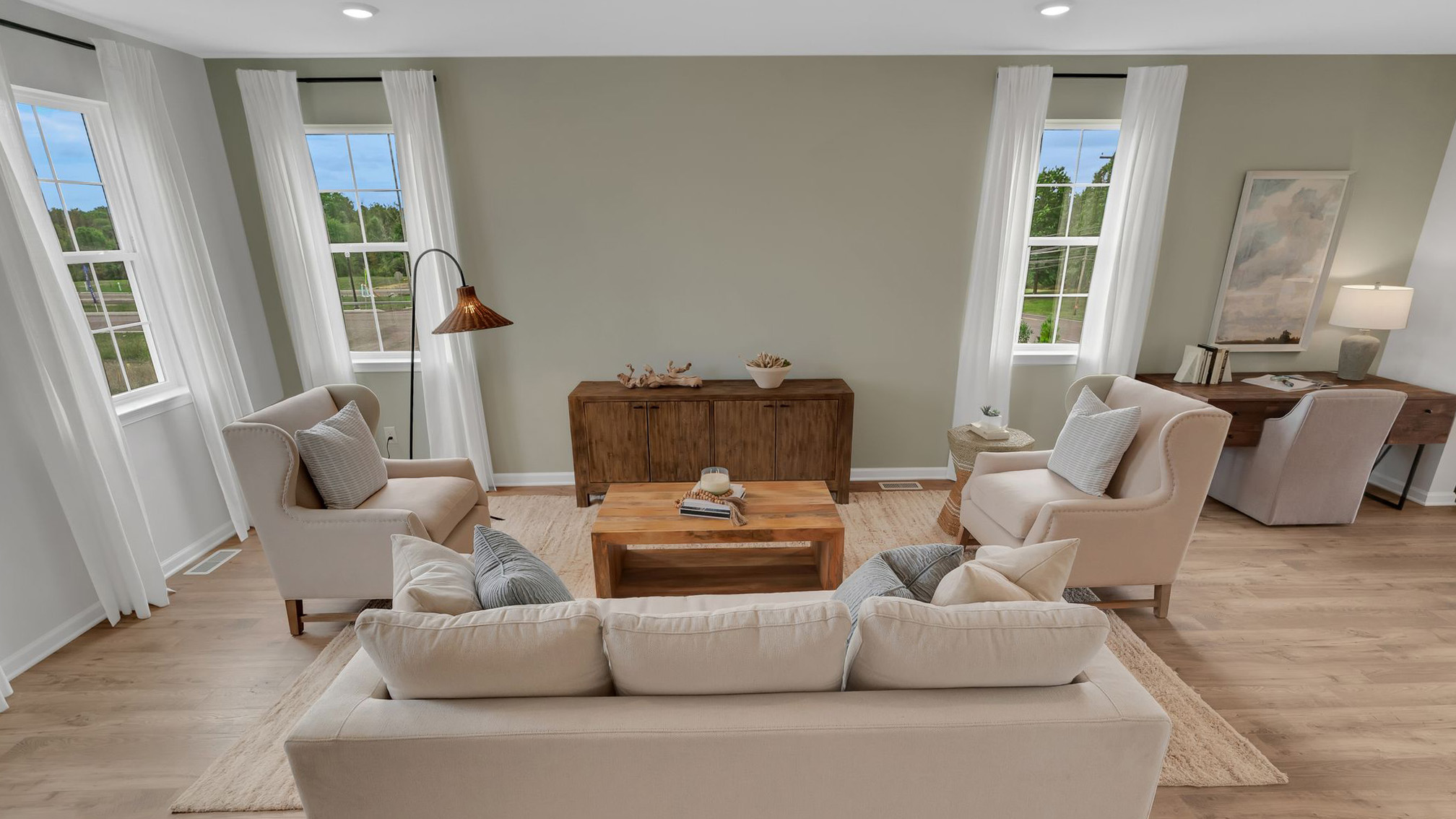 Living area only with a desk situated in the right corner. Two single windows in front and one single window to the left.