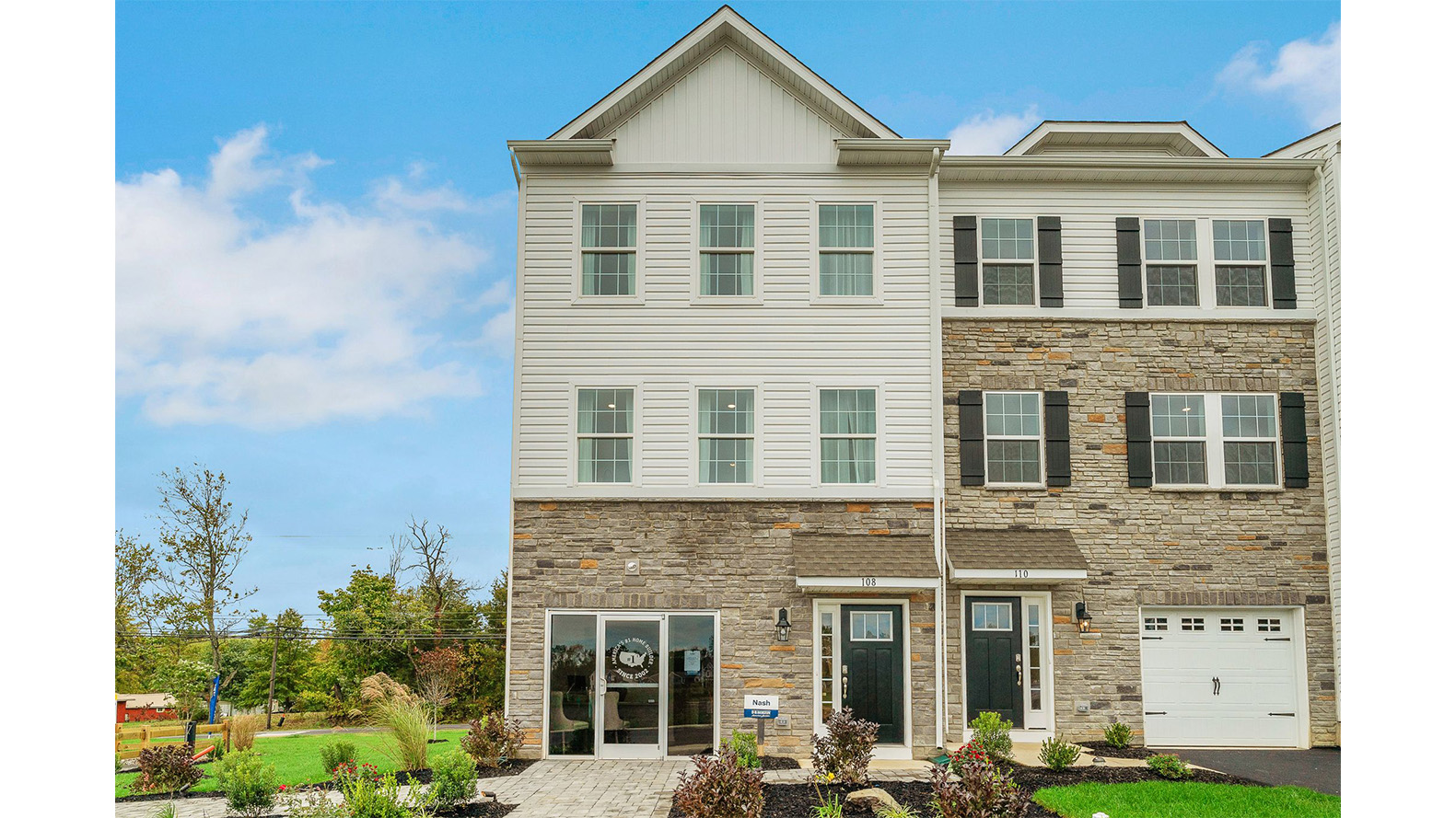 Exterior back image of a three story townhome with white horizontal paneling, the second story balcony, and the first floor back sliding glass door.