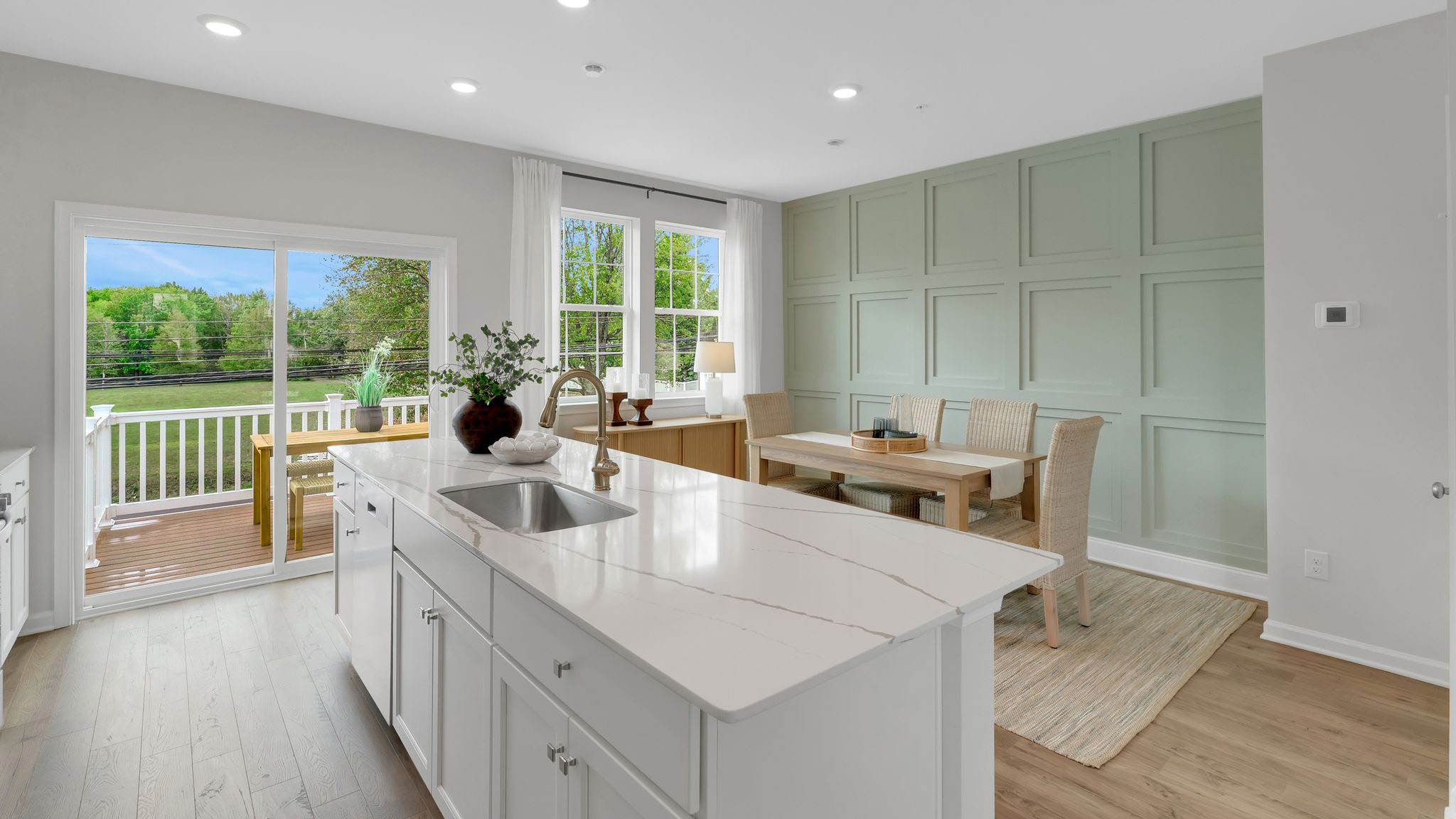 Kitchen area with view of the inside of the island, the balcony area, and the dining area in the back.