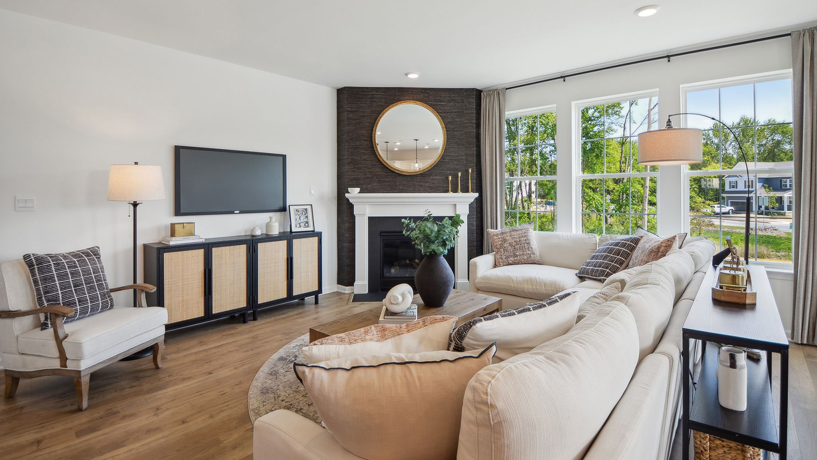 Living area with fireplace and three large single windows for optimal natural lighting.