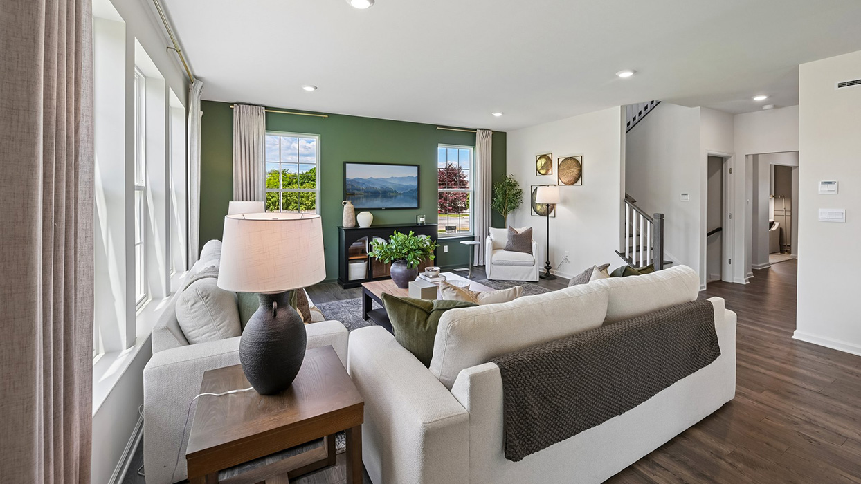 Living area with view of staircase, main hallway, and five windows.