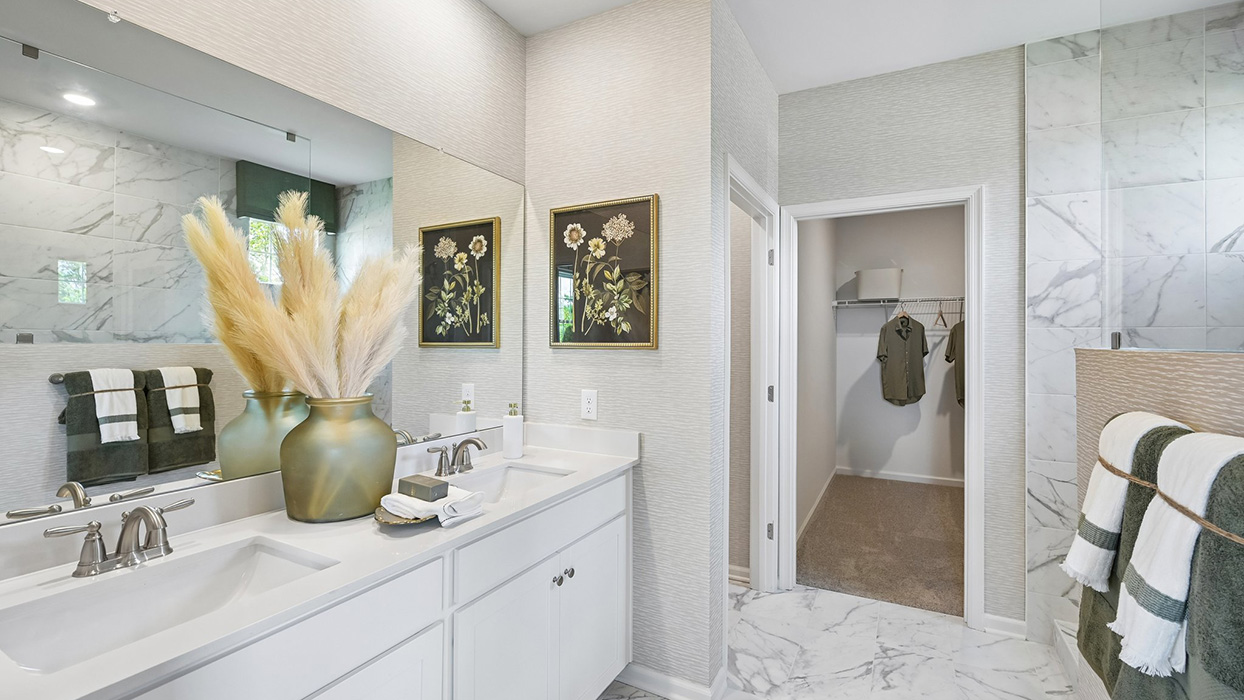 Master bathroom has dual vanity and leads into walk-in closet.