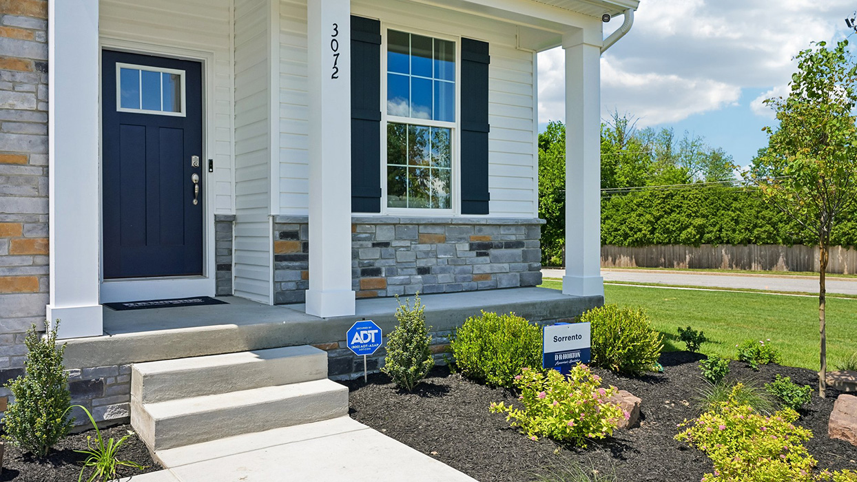 Front porch featuring dark blue door and stone accenting.