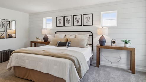 Different view of the bedroom with two small high windows on either side of the bed.