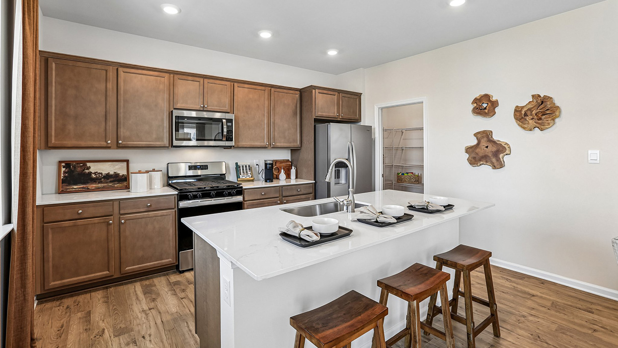The well-designed gourmet kitchen features beautiful countertops and island seating.