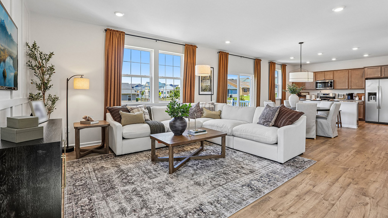 A wide angle view of the open concept living area, dining, and kithcen in the back right corner.