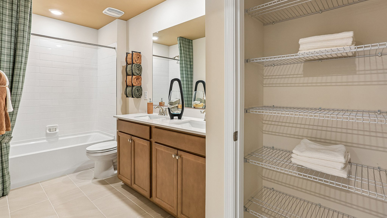 A spacious hall bathroom with double vanity and shower.