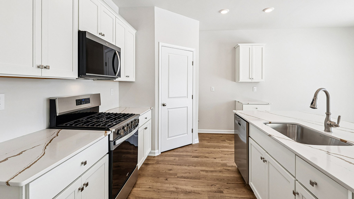 Kitchen area from the inside of the island and dining area in the back right corner.
