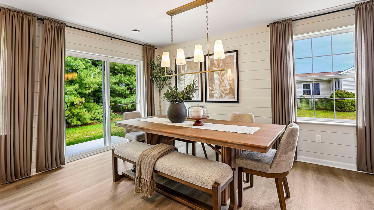 Dining area with large windows and sliding glass door, offering abundant natural light and easy indoor-outdoor flow