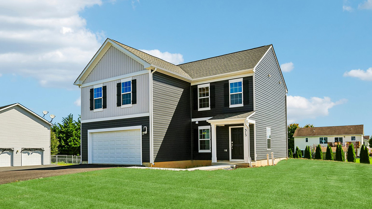 A side photo of a Deerfield home with wicker primary siding, midnight surf board and batten accent siding, and a white two car garage.