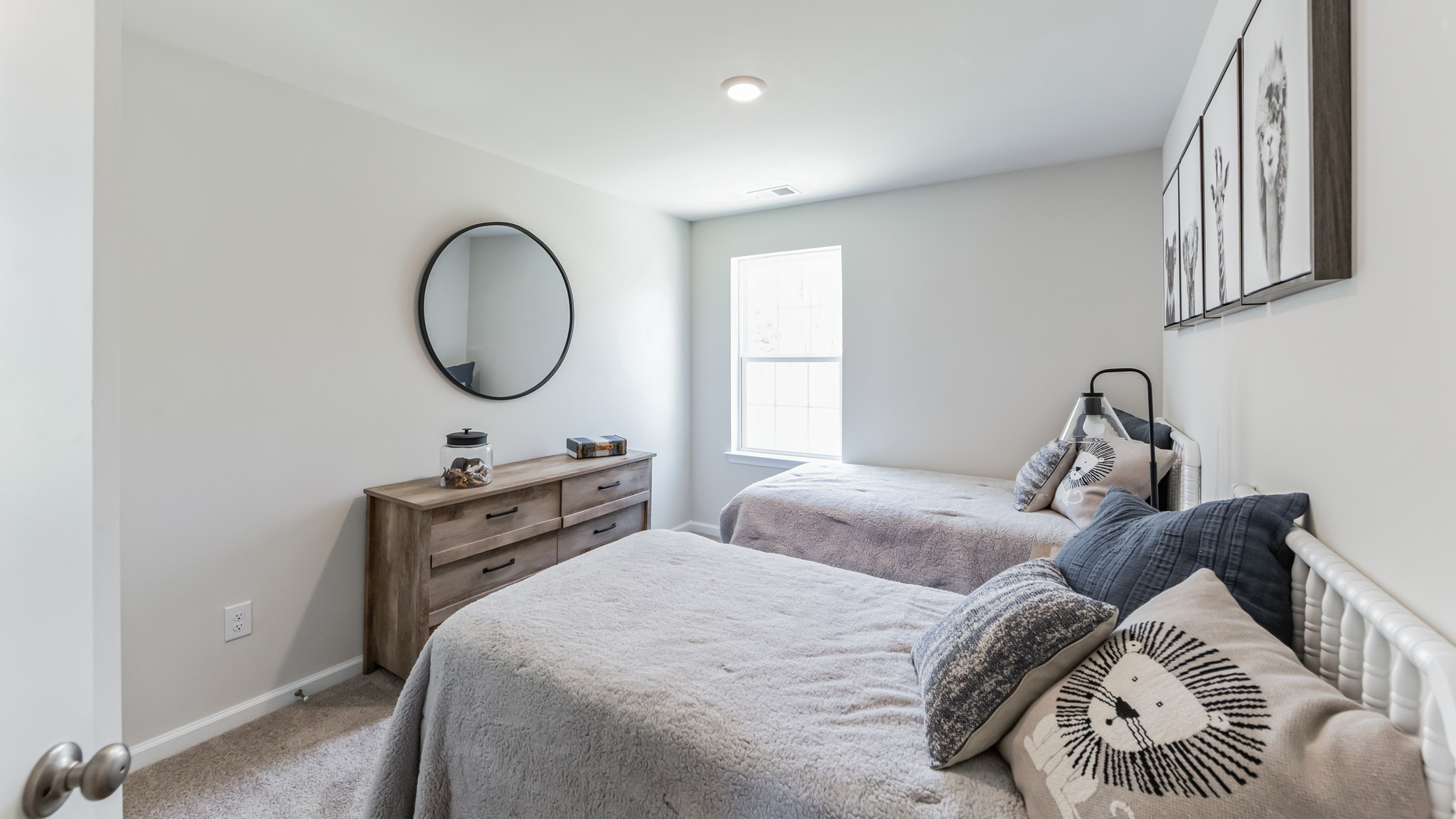 A guest bedroom with two beds and one window.
