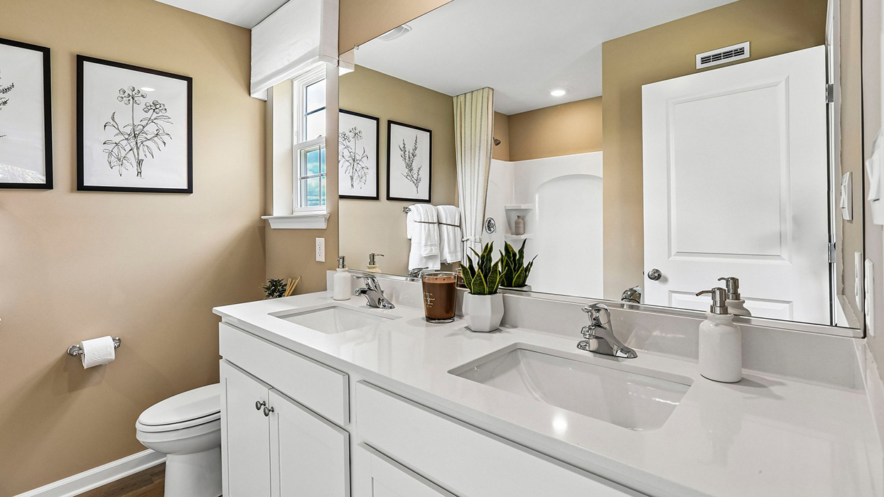 Bathroom with dual vanity sinks and extended countertop offering functional space and storage