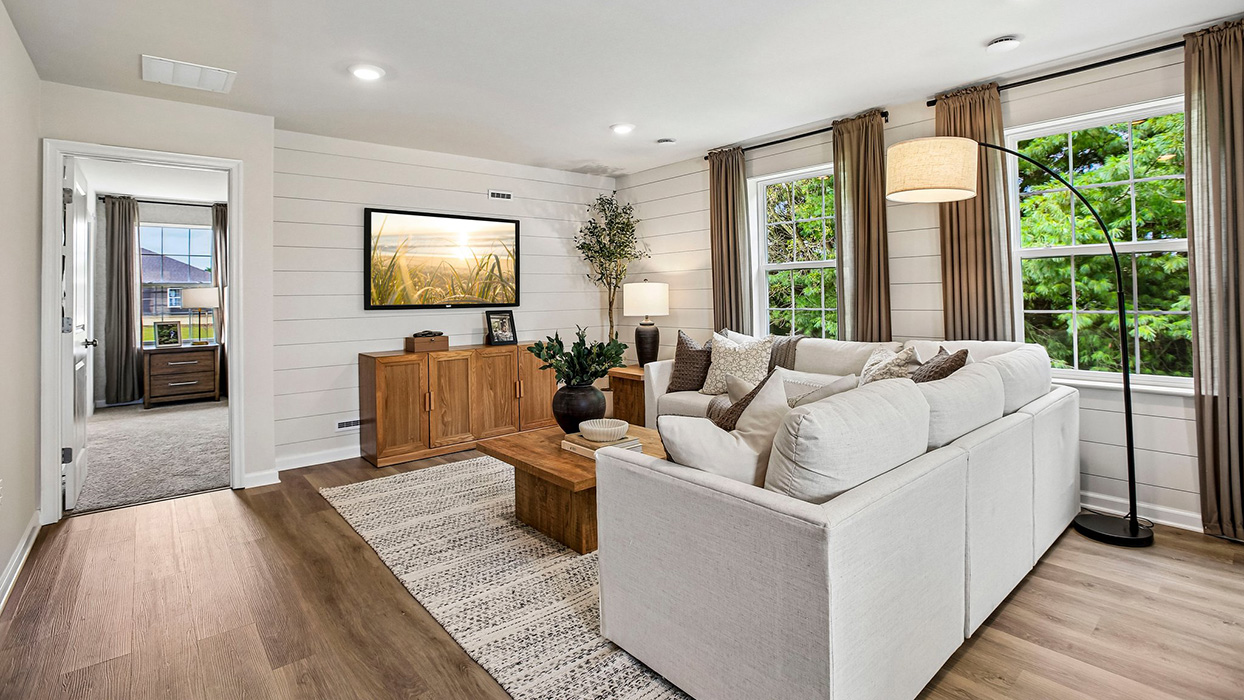 Open-concept living room with spacious layout, multiple windows, and strong natural light throughout