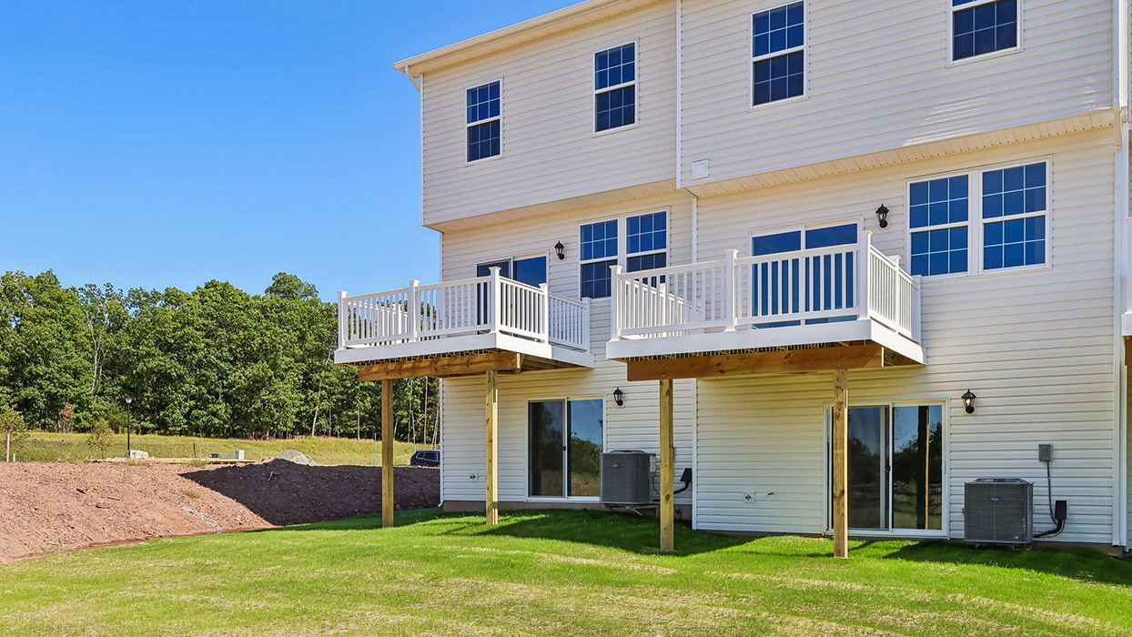 A photo of the back side of a Creekside Village 5 unit townhome building in the Lafayette floor plan