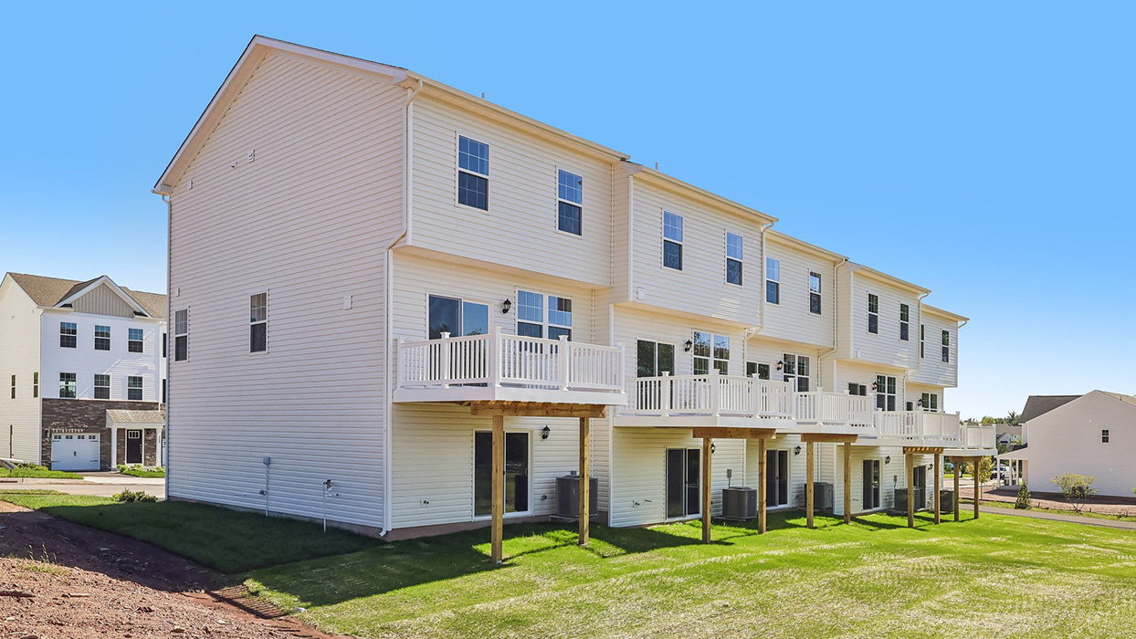 A photo of the back side of a Creekside Village 5 unit townhome building in the Lafayette floor plan