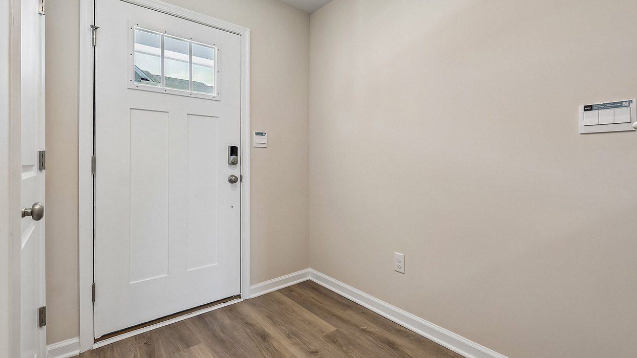 A view of the lower level hallway with stairwell leading up to the main living level.