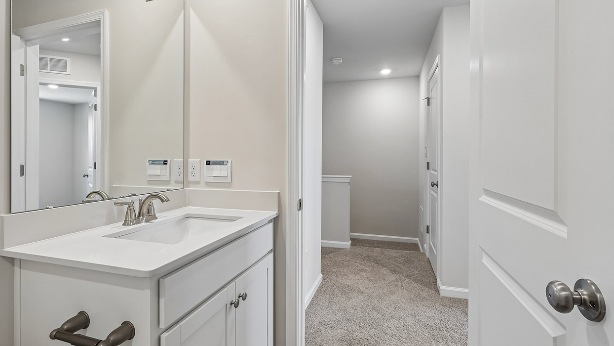 Second bathroom with a single sink white vanity.