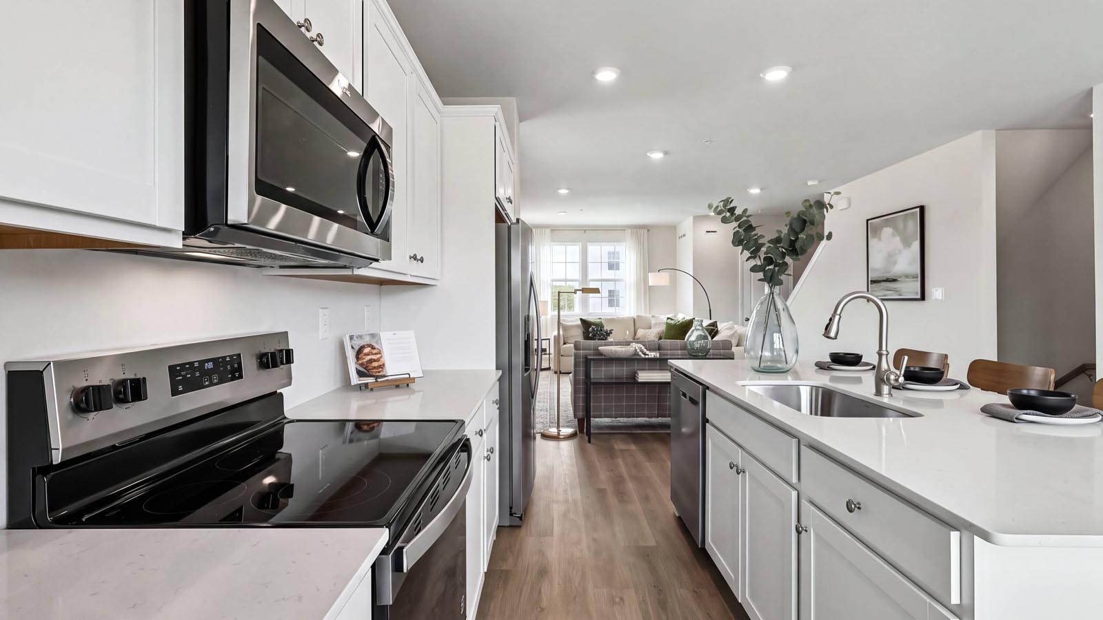 A view of the kitchen with white cabinets and stainless steel appliances.