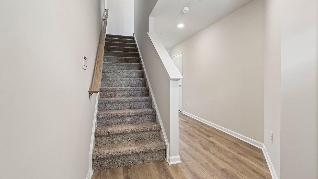 A view of the lower level hallway leading from the finished rec room to the foyer entrance.