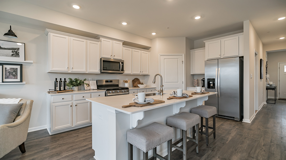 Kitchen with pantry in the corner and large island with view into the foyer hall.