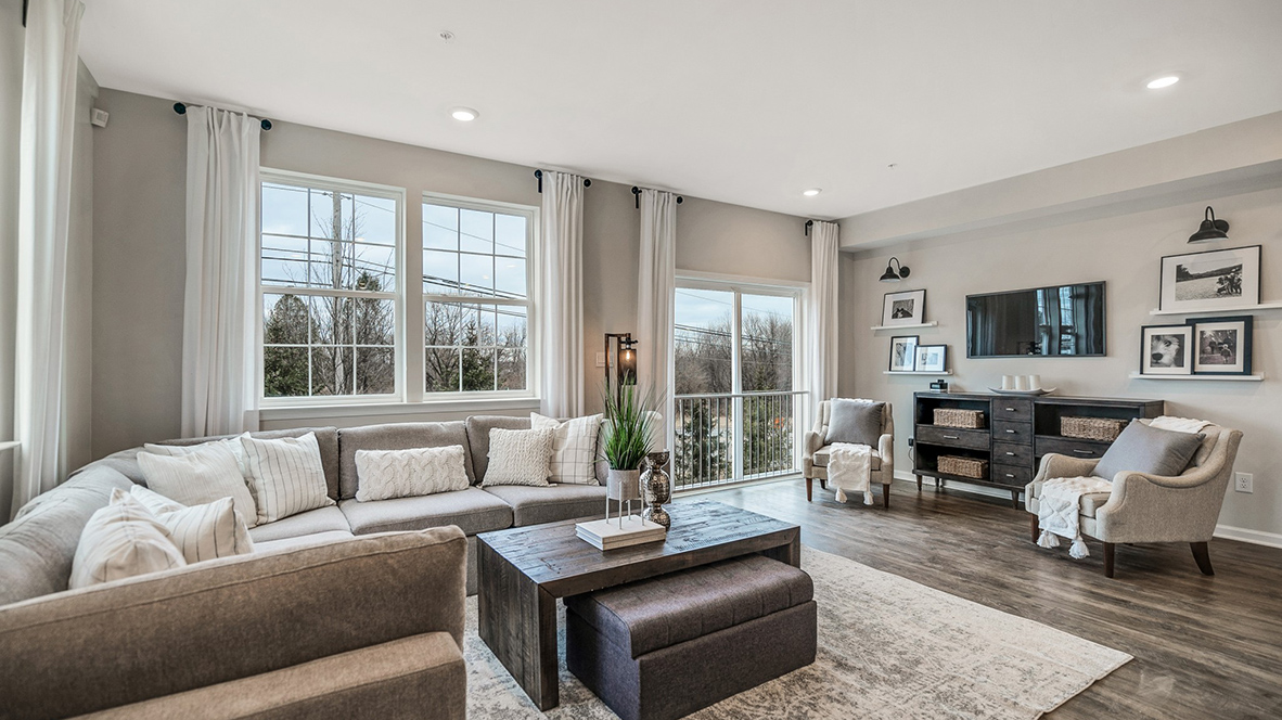 Spacious living area with several windows incasing the space with the Juliet balcony glass door.