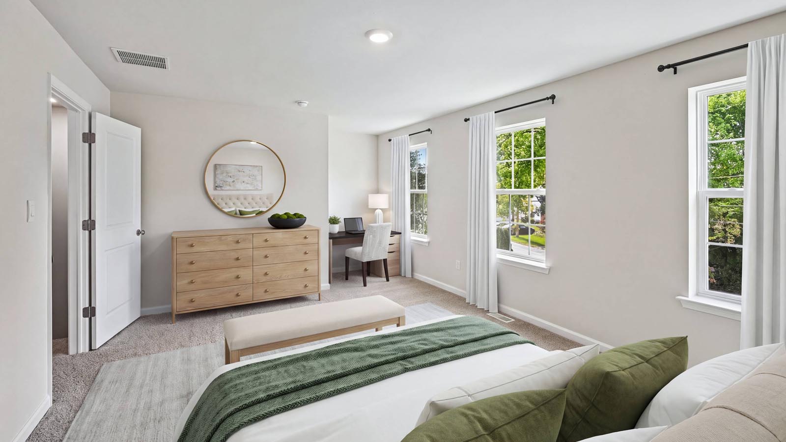 Primary bedroom on the second floor with three windows.