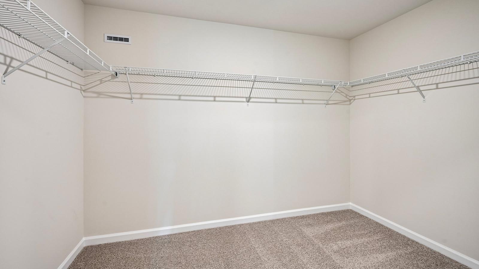 Large connecting closet off the primary bath with racks and shelves.