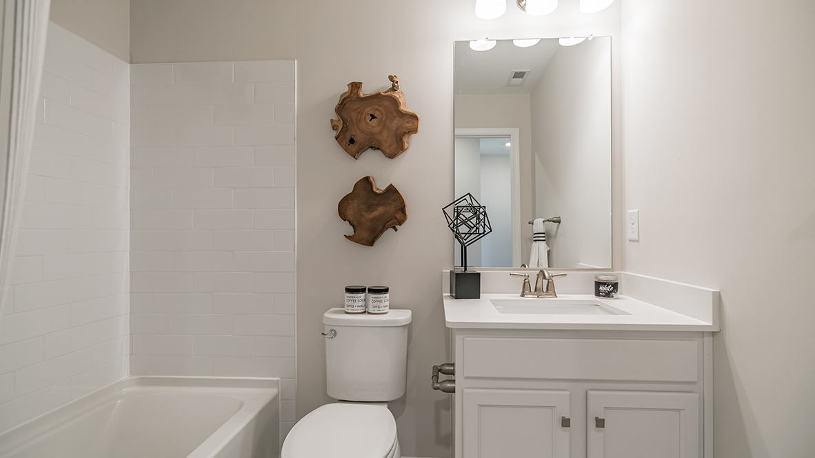 Secondary bath on the second floor with single sink vanity and shower tub.