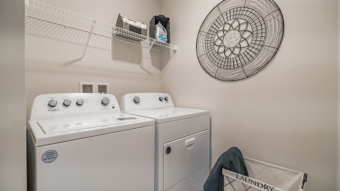 Laundry room with washer and dryer with shelf above.