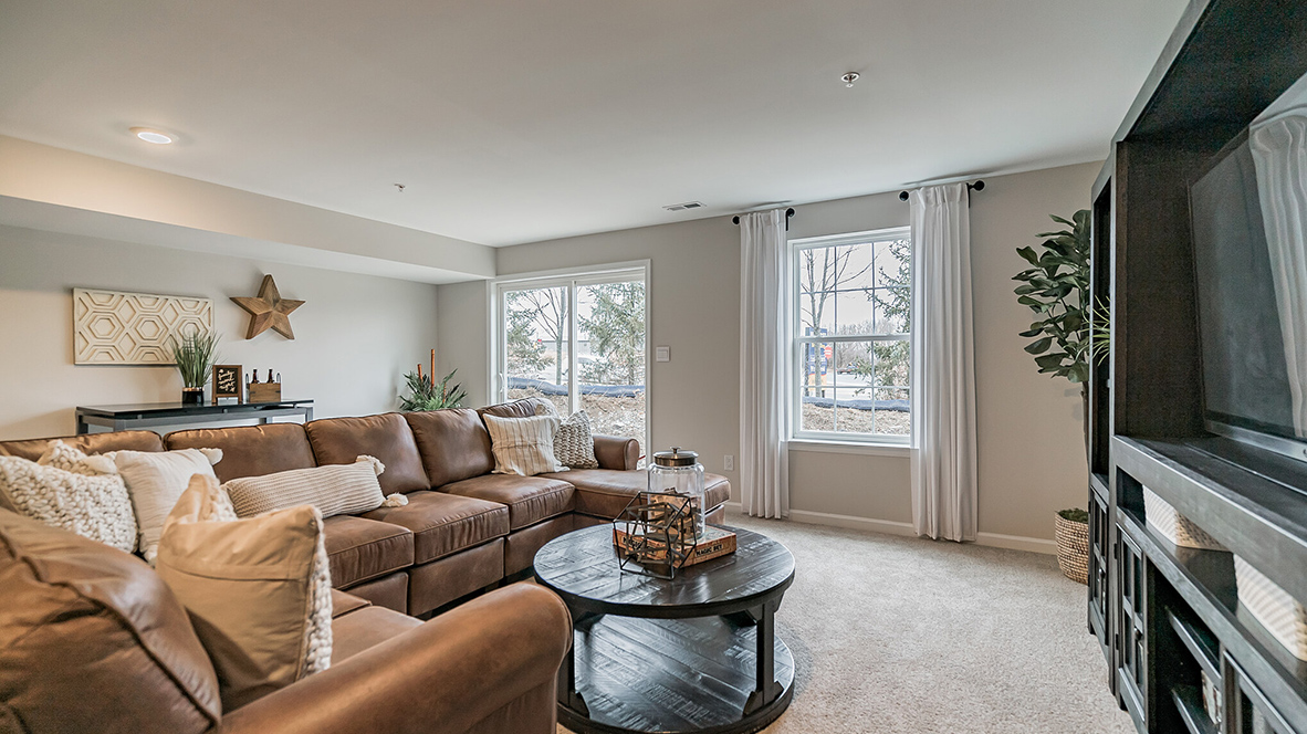 Recreation room of the finished basement with the back sliding glass door to the backyard.