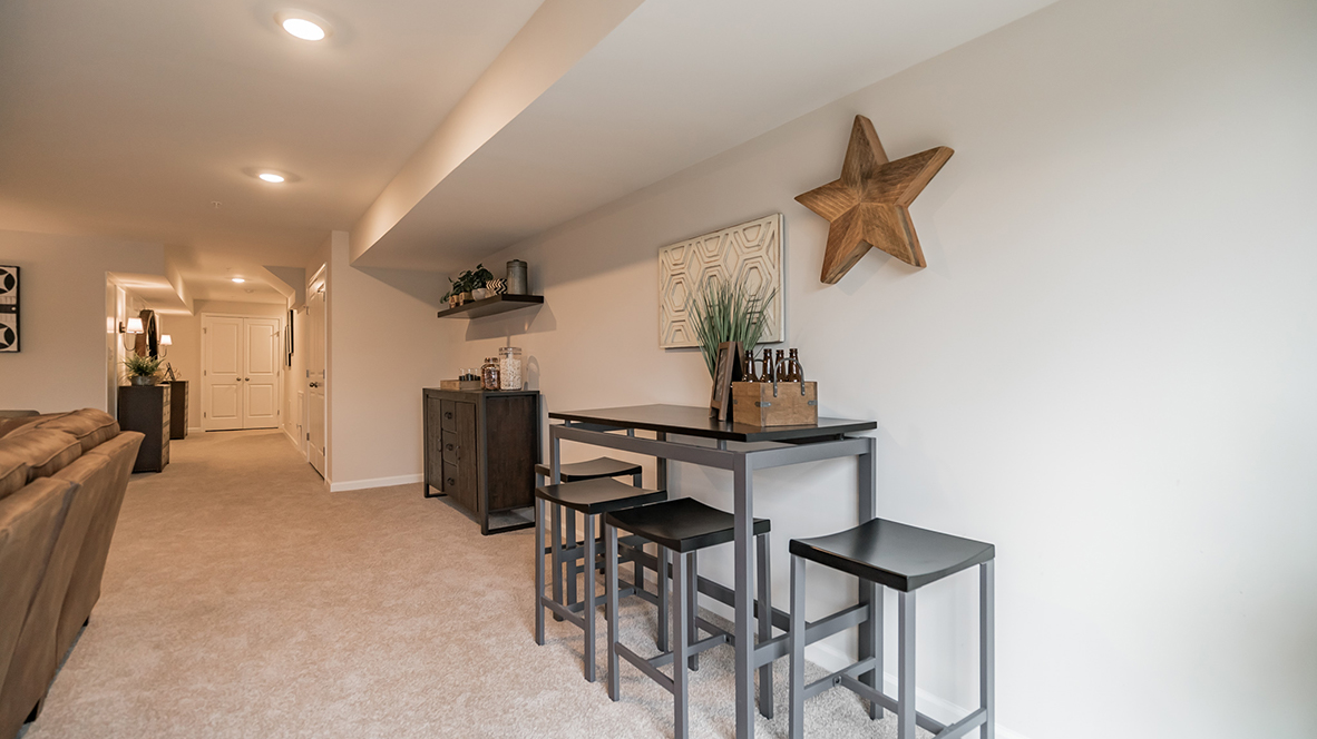 Recreation room with view into hallway next to the stairs.