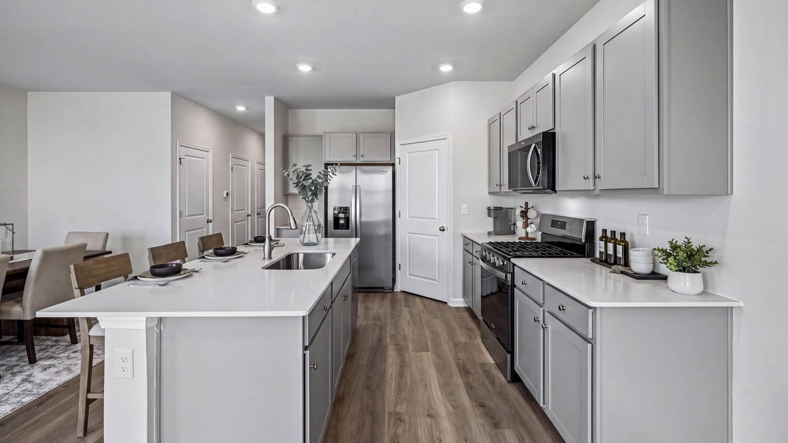 Kitchen with pantry in the corner and large island with view into the foyer hall.