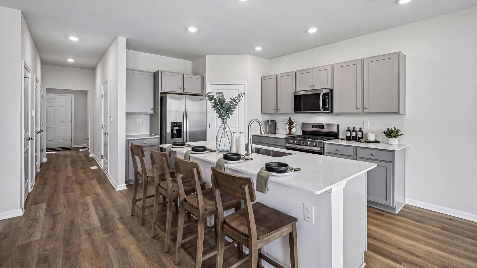Kitchen with pantry in the corner and large island with view into the foyer hall.
