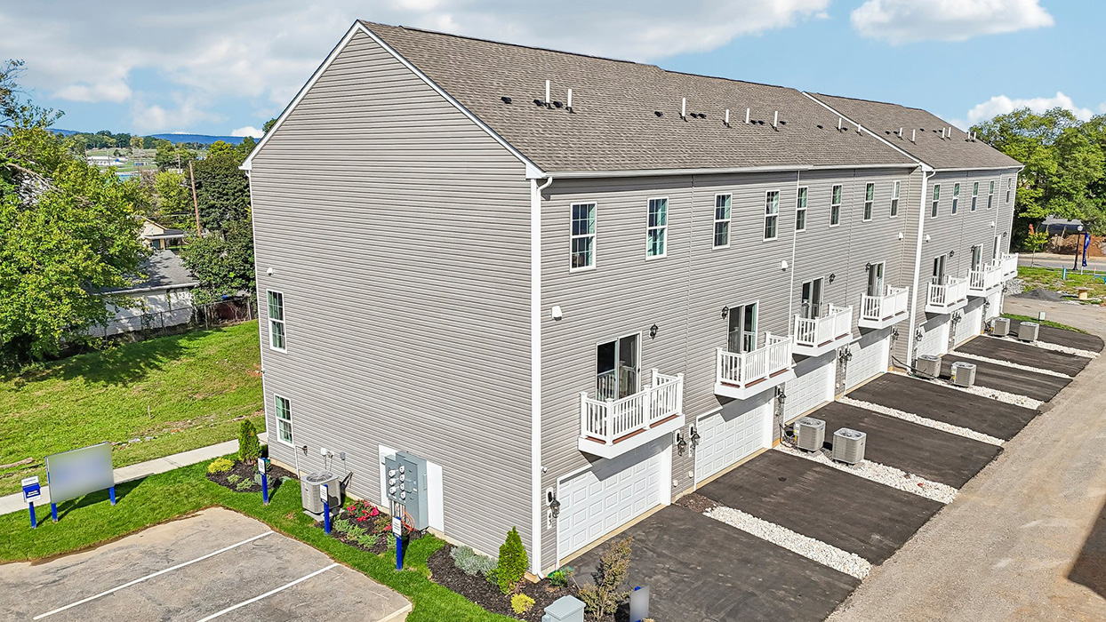 a photo of the norris plan 6-unit townhome building with slate gray color siding dark gray shutters and a navy front door
