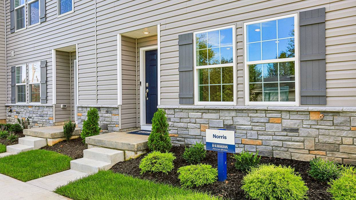 a photo of the norris plan 6-unit townhome building with slate gray color siding dark gray shutters and a navy front door