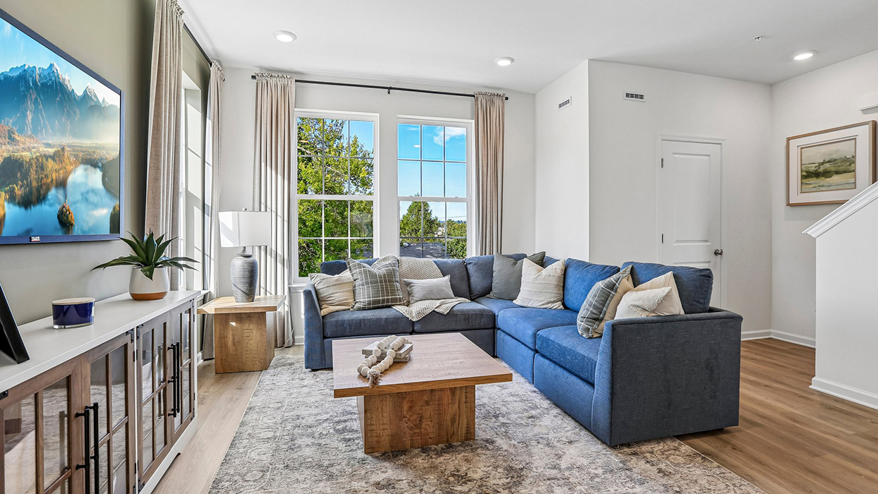 Living room and a view of the coat closet and stairwell to bedroom level