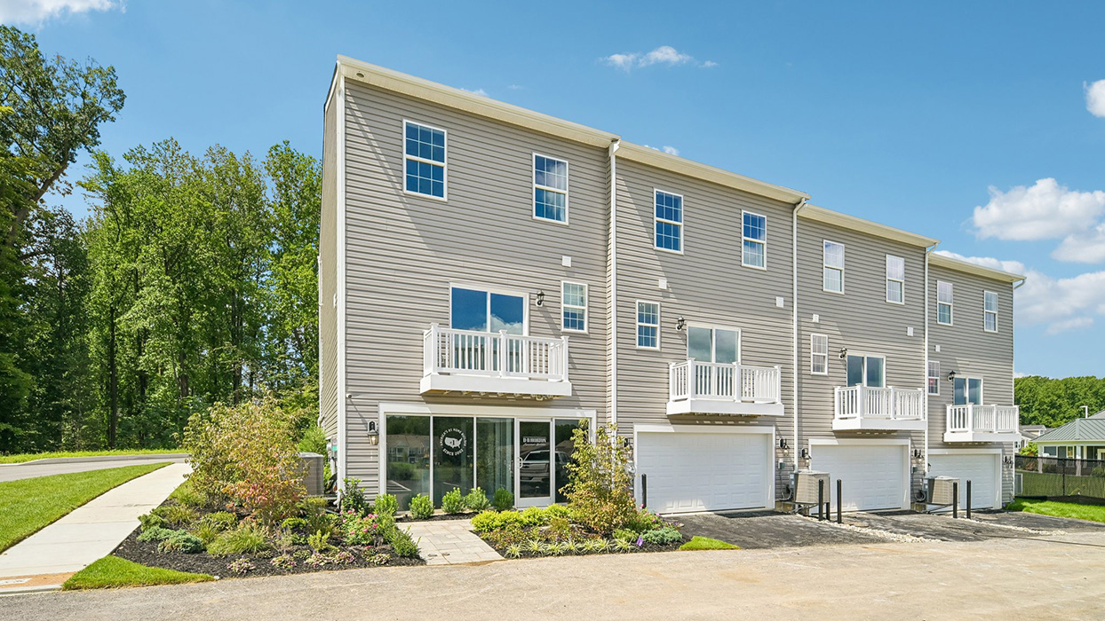 A rear view of a Norris 3 story townhome model unit with ground level sales center office
