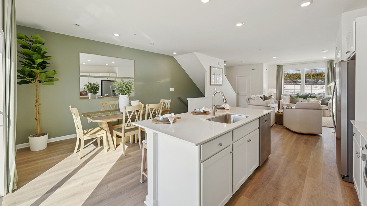 Open-concept view from kitchen island toward dining and living areas, highlighting natural light and spacious layout