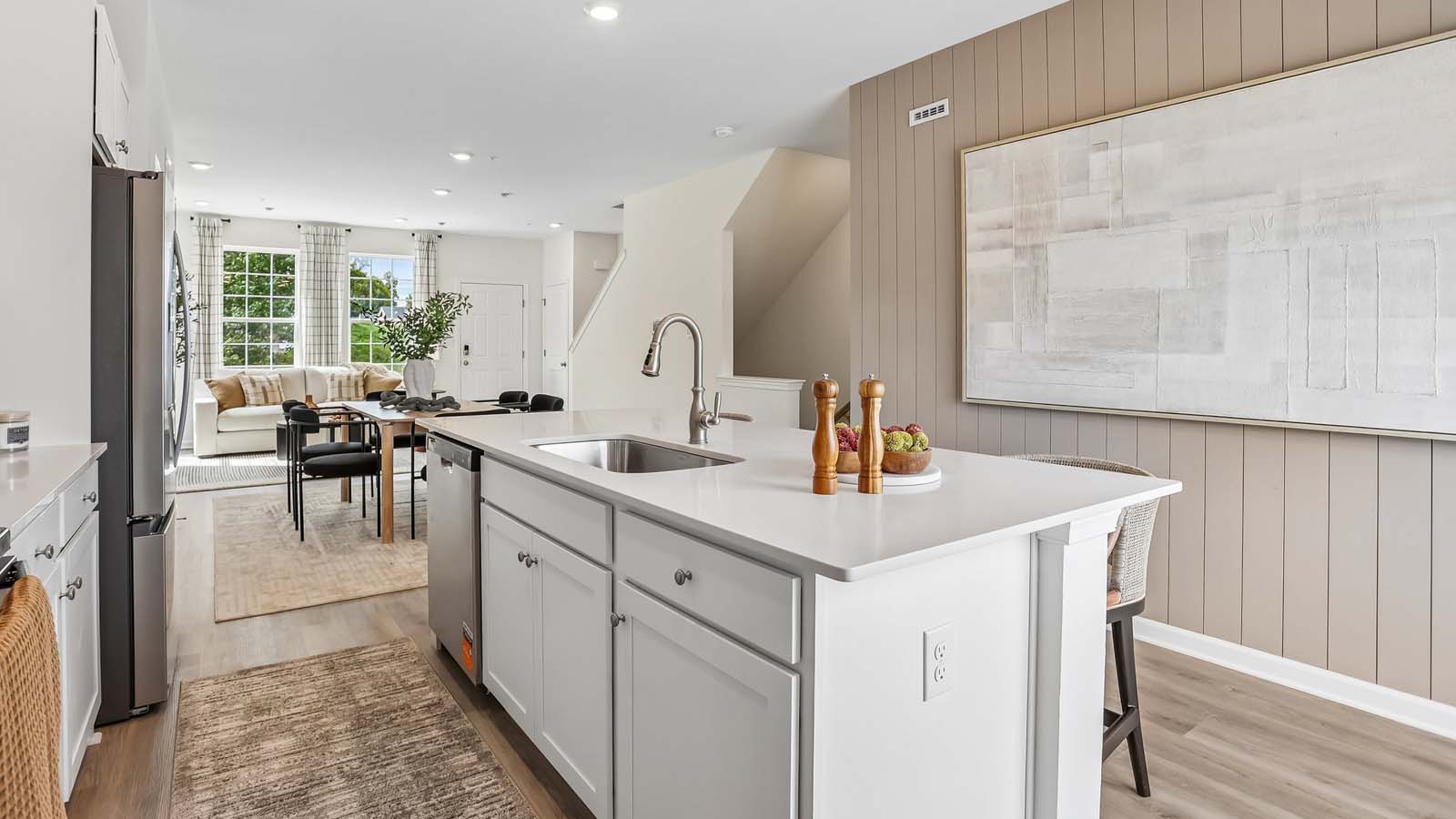 Bright spacious kitchen area with large island with white counter tops and white cabinetry