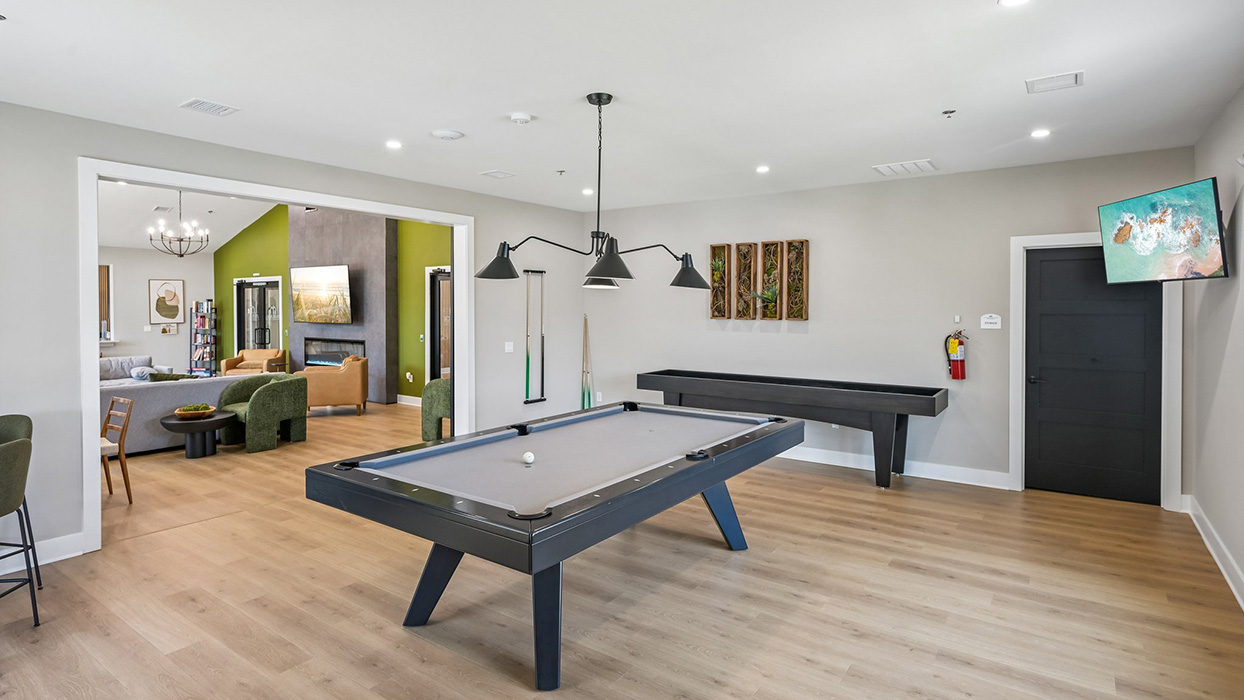 Game room featuring pool table, overhead lighting, and adjacent shuffleboard table in an open layout
