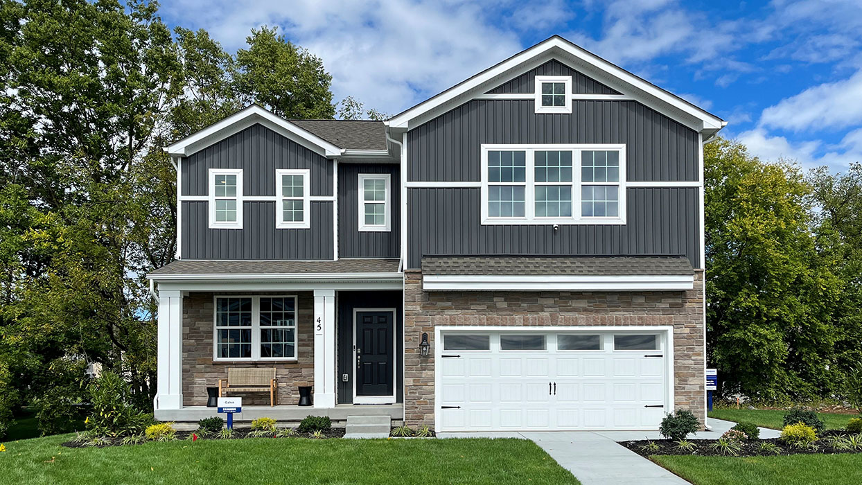 A rendering of a two-story Galen home with sterling board and batten accent siding, white trim, and aspen ledgestone siding surrounding the first floor entrance and around a white two car garage.