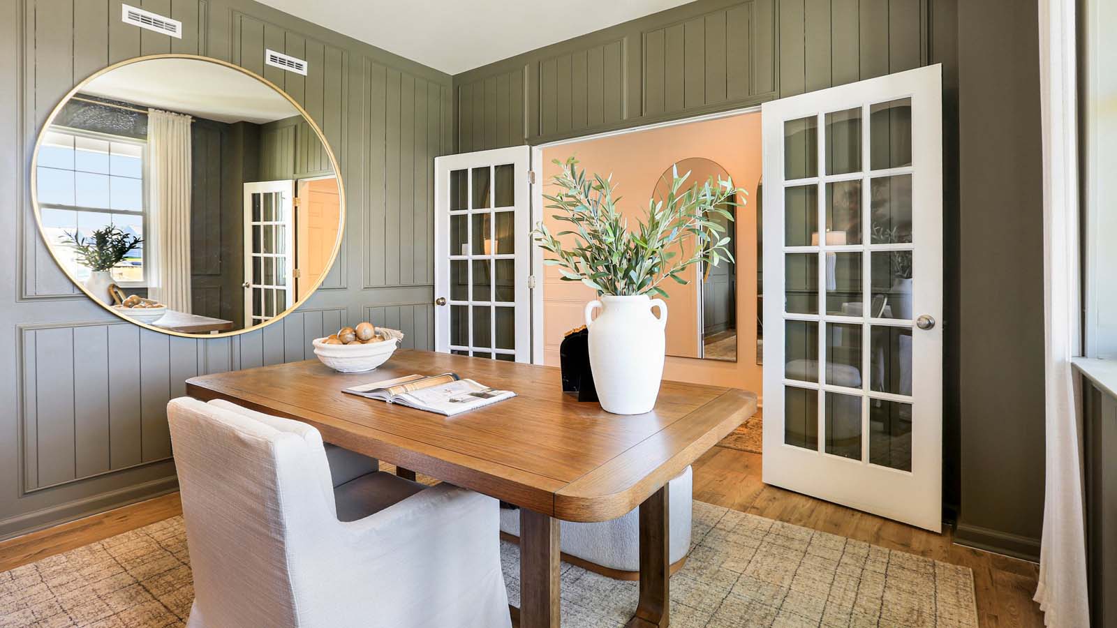 Flex room near entry, natural light, and open doorway to additional living or dining area.