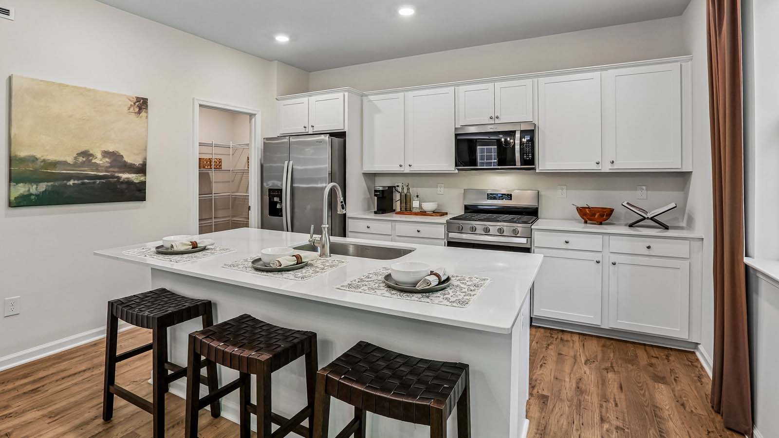 The well-designed gourmet kitchen features beautiful countertops and island seating.