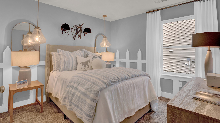 Secondary bedroom with cozy styling, accent wall design, and bedside lighting in a thoughtfully designed new home