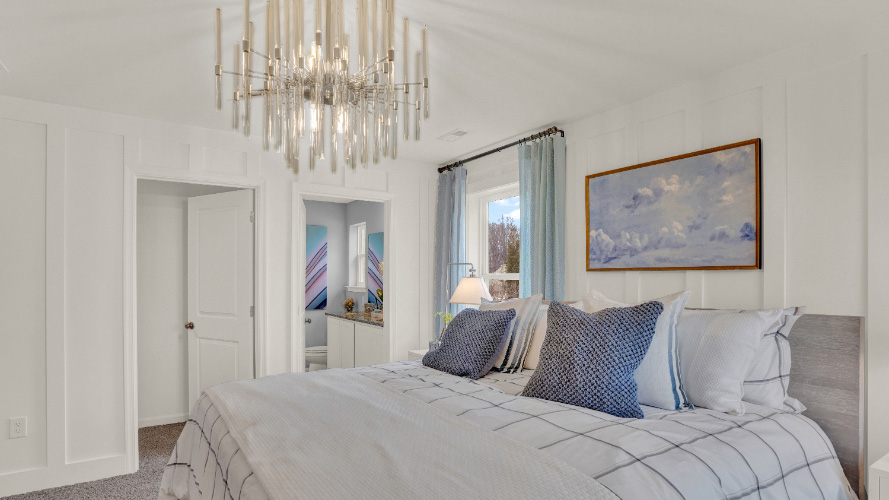 Primary bedroom with high ceiling, ample floor space, and private bath access