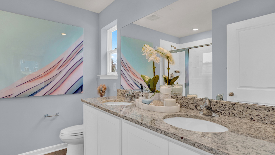 Bathroom with dual vanity sinks and extended countertop offering functional space and storage