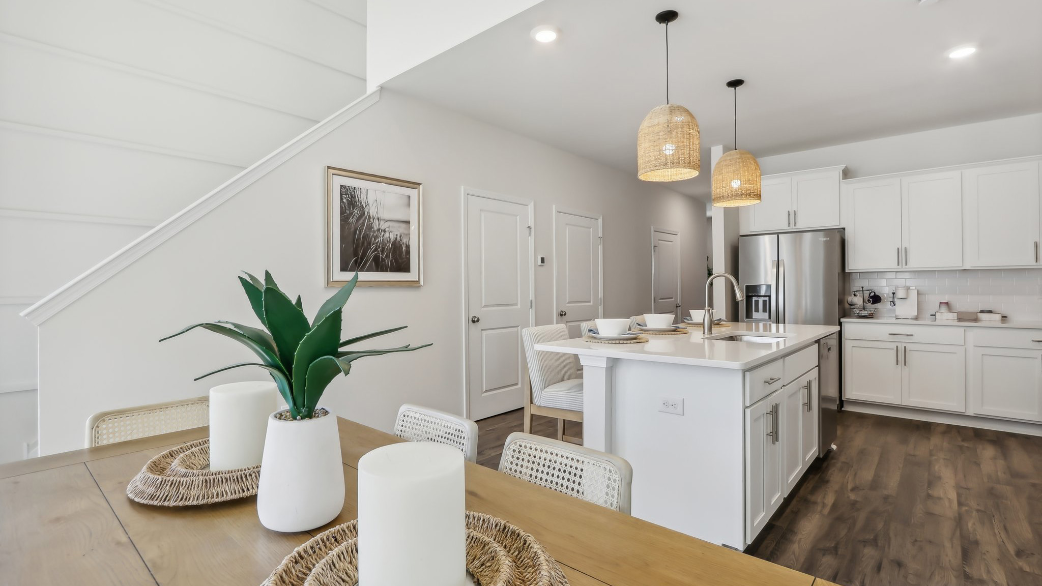 white kitchen with white island and stainless-steel appliances and silver