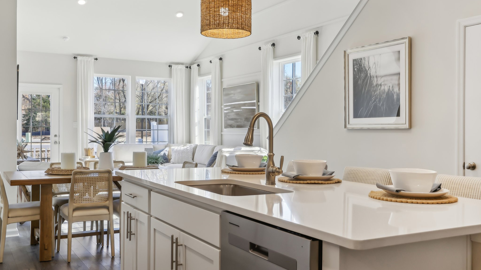 white kitchen with white island and stainless-steel appliances and silver
